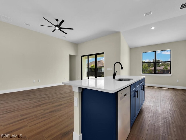 kitchen featuring blue cabinetry, stainless steel dishwasher, sink, dark wood-type flooring, and an island with sink