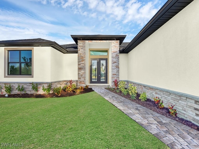 entrance to property featuring french doors and a yard