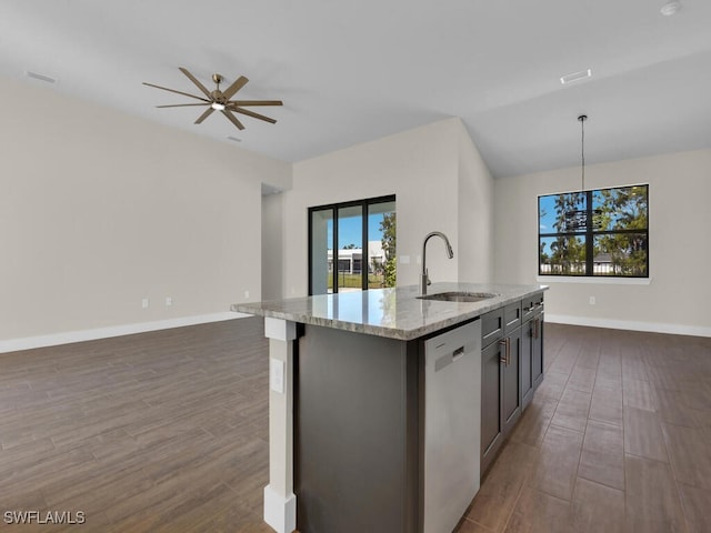 kitchen featuring stainless steel dishwasher, light stone countertops, a sink, dark wood-style floors, and open floor plan