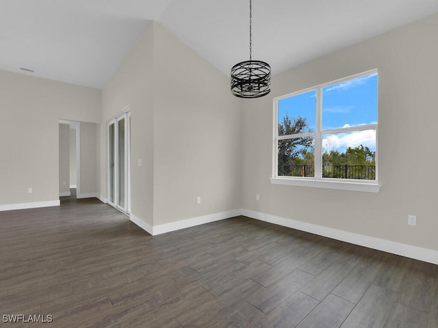 unfurnished room featuring baseboards, a notable chandelier, and dark wood-type flooring