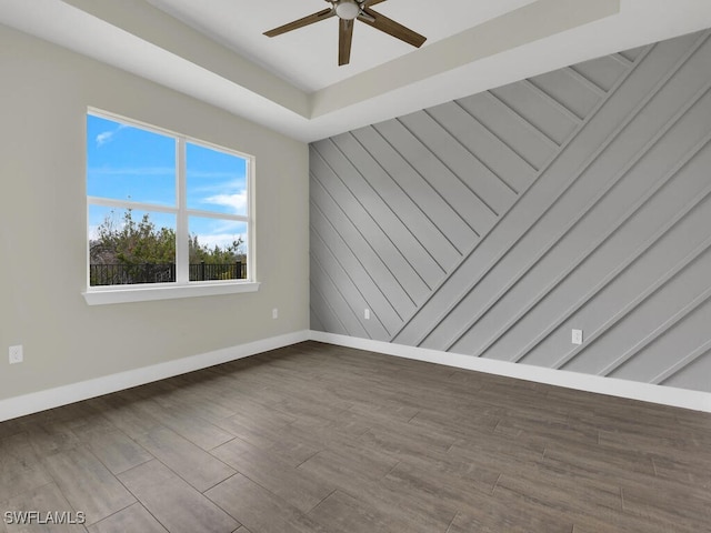 unfurnished room with baseboards, ceiling fan, and wood finished floors