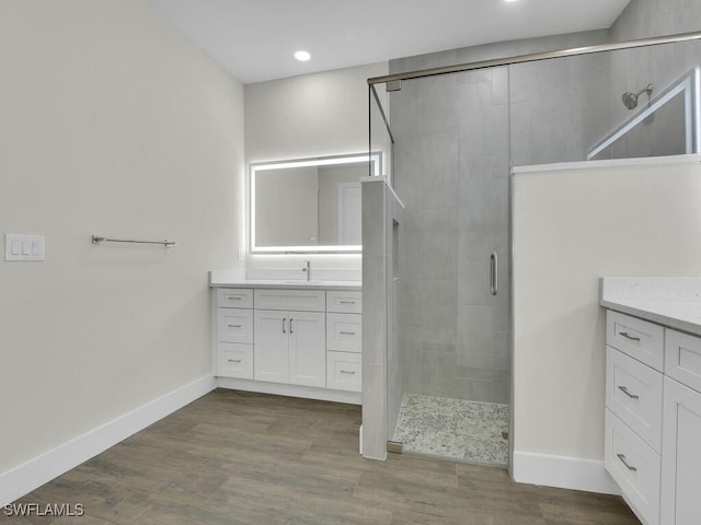 full bath with vanity, baseboards, wood finished floors, and a shower stall