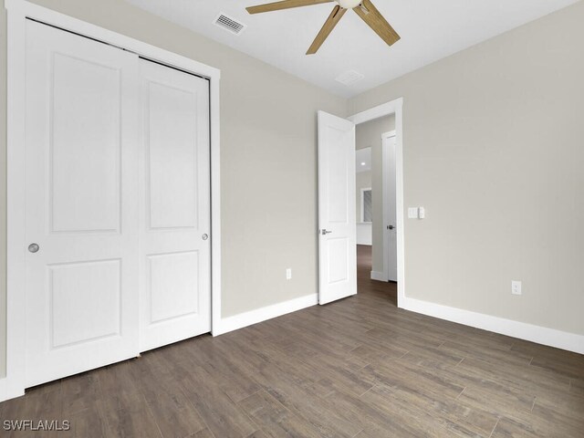 unfurnished bedroom featuring visible vents, baseboards, wood finished floors, and a closet