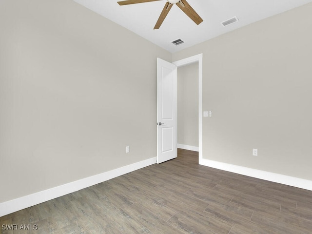 unfurnished room with baseboards, a ceiling fan, wood finished floors, and visible vents