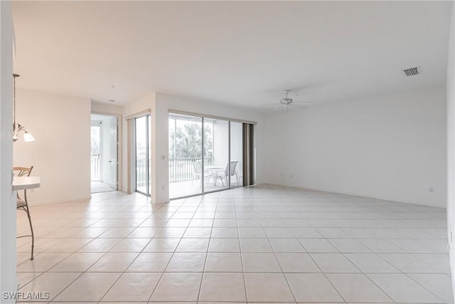 tiled empty room with ceiling fan with notable chandelier