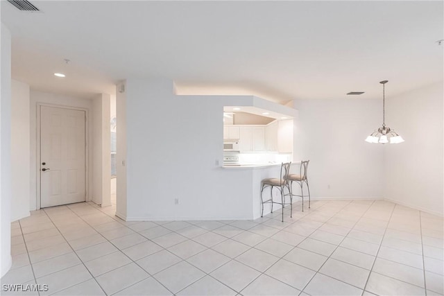 interior space with white cabinetry, kitchen peninsula, a notable chandelier, light tile patterned flooring, and pendant lighting