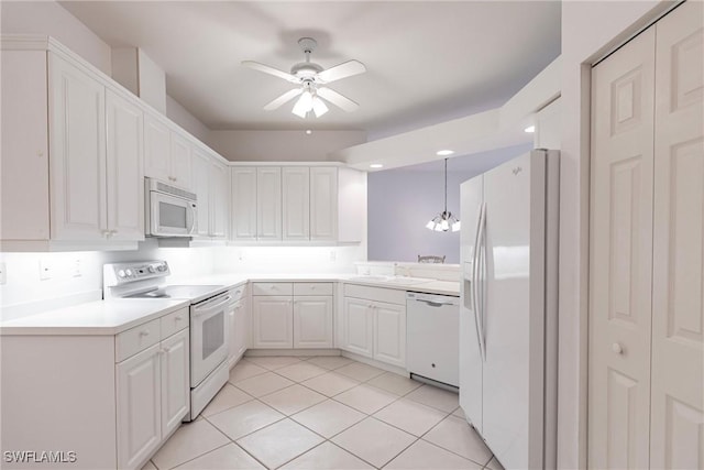 kitchen with light tile patterned floors, decorative light fixtures, white appliances, ceiling fan with notable chandelier, and white cabinets