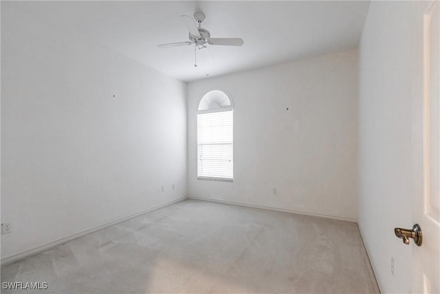 empty room featuring ceiling fan and light colored carpet