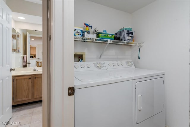 washroom with light tile patterned flooring, independent washer and dryer, and sink