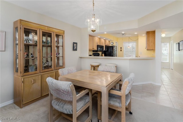 tiled dining space featuring ceiling fan with notable chandelier