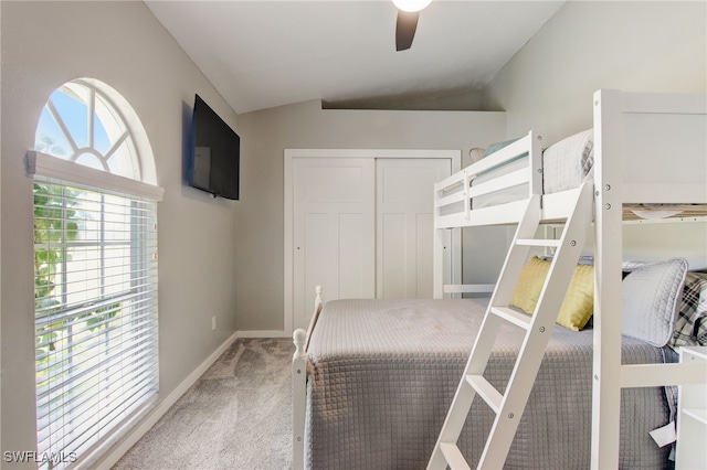 bedroom with ceiling fan, carpet, a closet, and vaulted ceiling