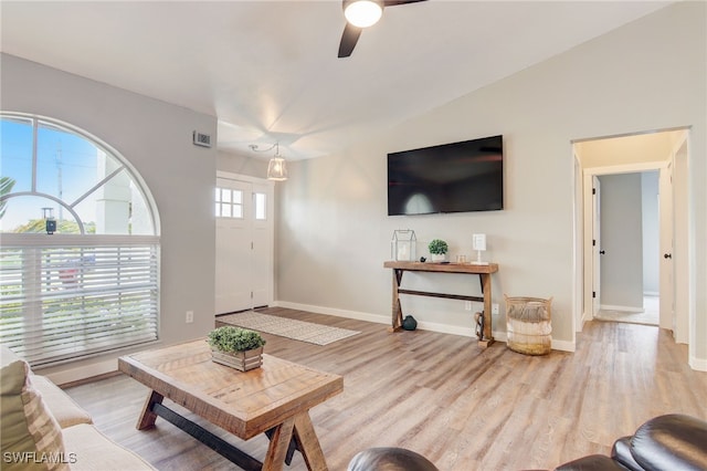 living room featuring ceiling fan, vaulted ceiling, and light wood-type flooring