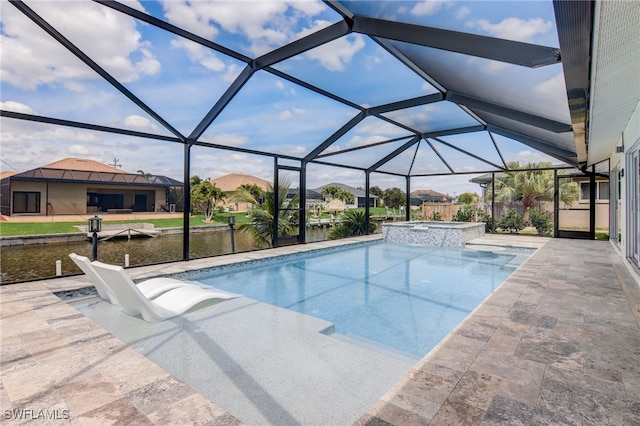 view of pool with glass enclosure, an in ground hot tub, a water view, and a patio