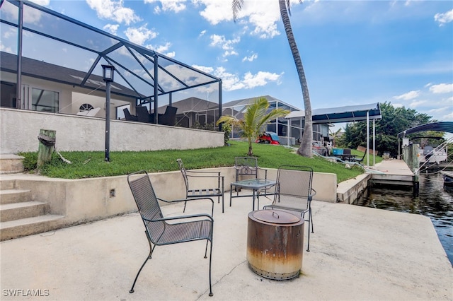 view of patio / terrace featuring a lanai, a dock, and a water view