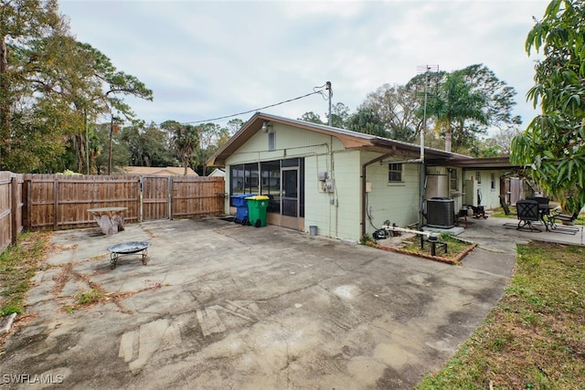 back of property featuring a patio area, cooling unit, and a fire pit