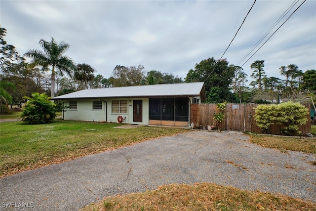 ranch-style home with a sunroom and a front lawn