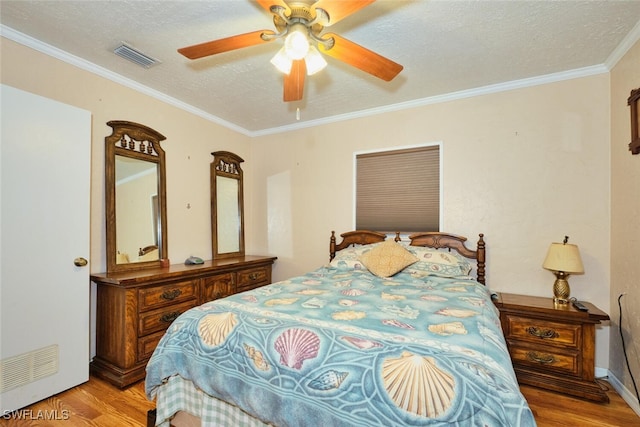 bedroom with ceiling fan, light hardwood / wood-style floors, a textured ceiling, and crown molding