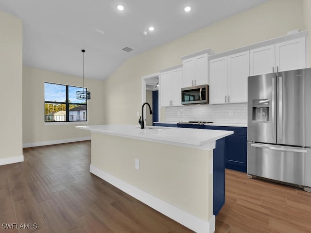 kitchen with sink, white cabinets, appliances with stainless steel finishes, and a center island with sink