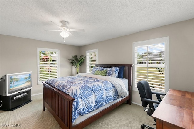 carpeted bedroom featuring a textured ceiling, ceiling fan, and multiple windows