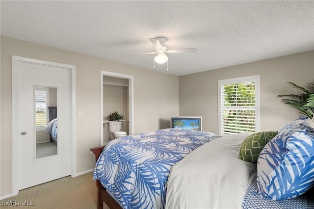 carpeted bedroom featuring a textured ceiling, ceiling fan, and ensuite bath