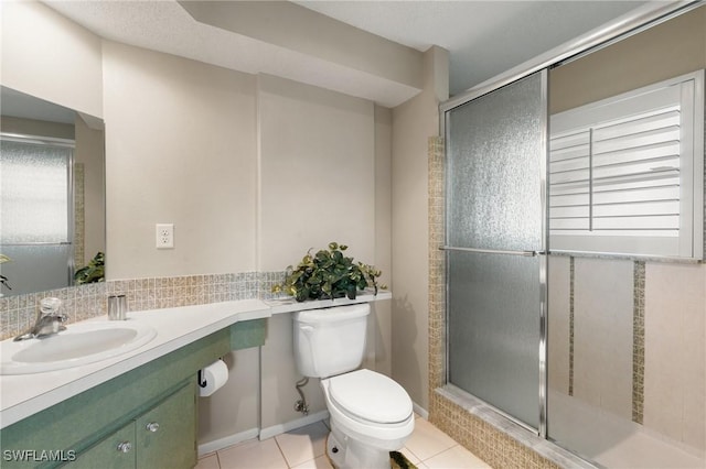 bathroom with a shower with shower door, plenty of natural light, toilet, and tile patterned flooring