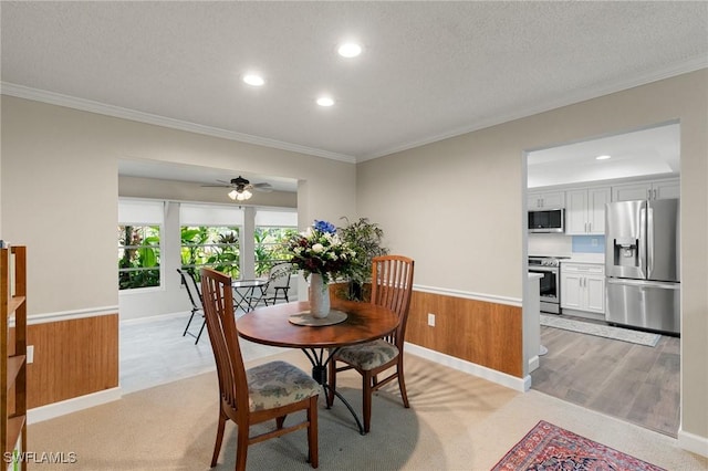 dining area with a textured ceiling, ceiling fan, and crown molding