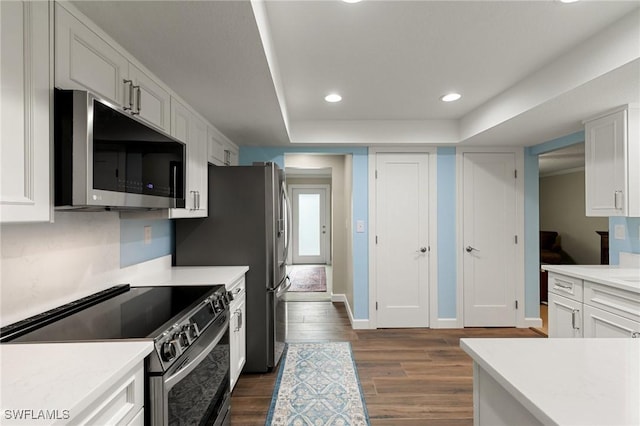 kitchen featuring appliances with stainless steel finishes, white cabinetry, and dark hardwood / wood-style floors