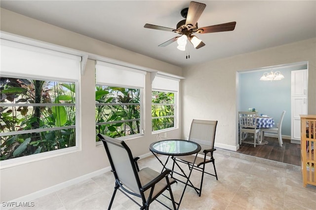 tiled dining area featuring ceiling fan with notable chandelier