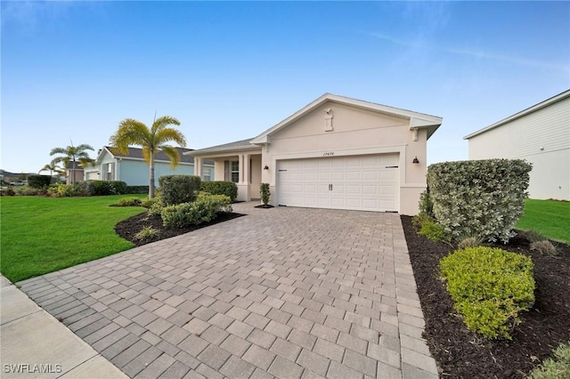 single story home featuring a garage, decorative driveway, a front lawn, and stucco siding