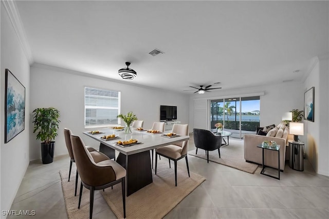 dining space with light tile patterned floors, ceiling fan, visible vents, and crown molding