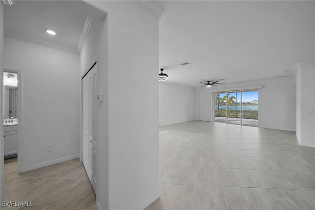 empty room featuring baseboards, visible vents, ceiling fan, ornamental molding, and a sink