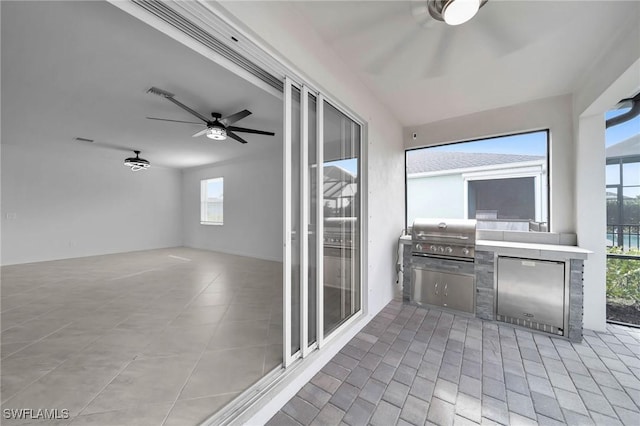 unfurnished sunroom featuring a ceiling fan