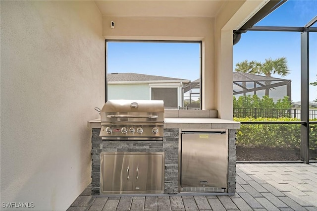 view of patio with a lanai, a grill, and area for grilling