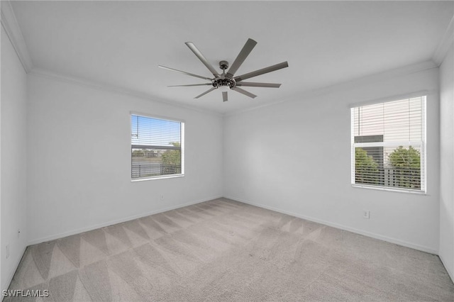 spare room featuring light carpet, ceiling fan, ornamental molding, and baseboards