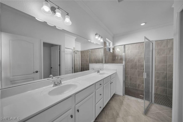 bathroom with crown molding, a stall shower, a sink, and double vanity