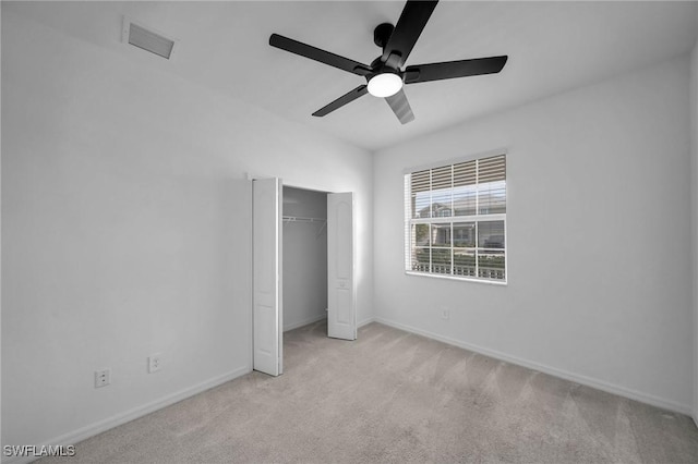 unfurnished bedroom featuring light carpet, a ceiling fan, visible vents, baseboards, and a closet