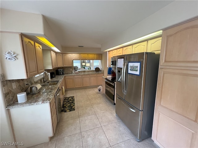 kitchen featuring appliances with stainless steel finishes, tasteful backsplash, light tile patterned flooring, light brown cabinetry, and sink