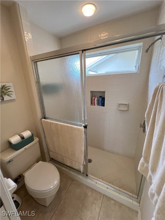 bathroom with toilet, tile patterned flooring, and walk in shower