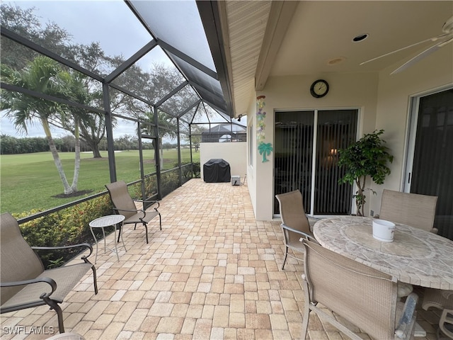 view of patio with glass enclosure and a grill