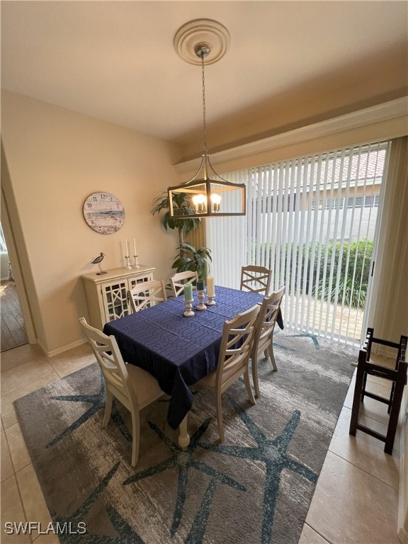 dining space with light tile patterned floors and a chandelier