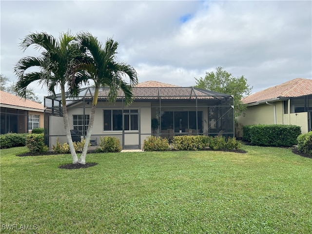 back of property featuring a lanai and a yard