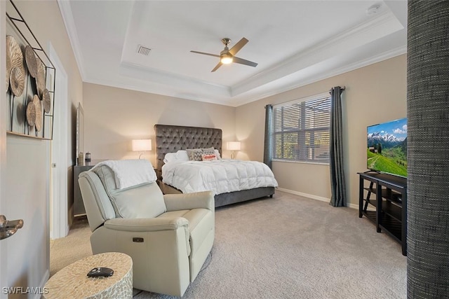 bedroom featuring ceiling fan, light colored carpet, ornamental molding, and a raised ceiling