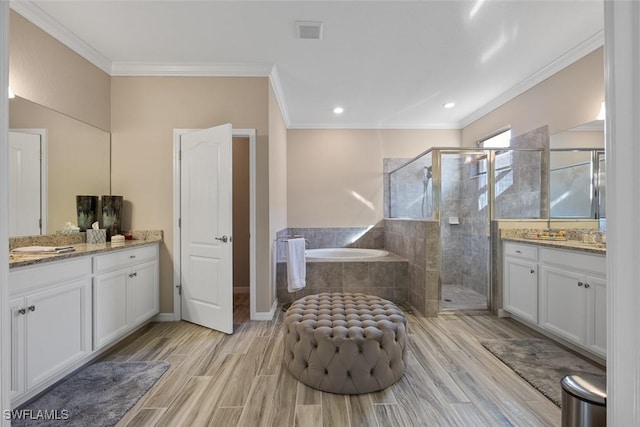 bathroom featuring independent shower and bath, crown molding, and vanity