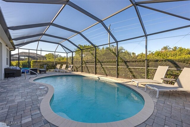 view of swimming pool with a lanai and a patio area