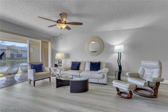 living room with a textured ceiling and ceiling fan