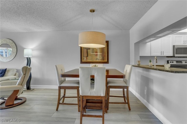 dining space with sink and a textured ceiling