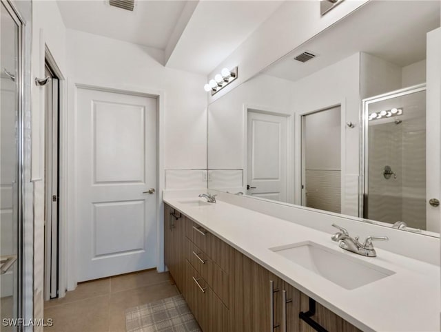 bathroom featuring vanity, tile patterned flooring, and walk in shower