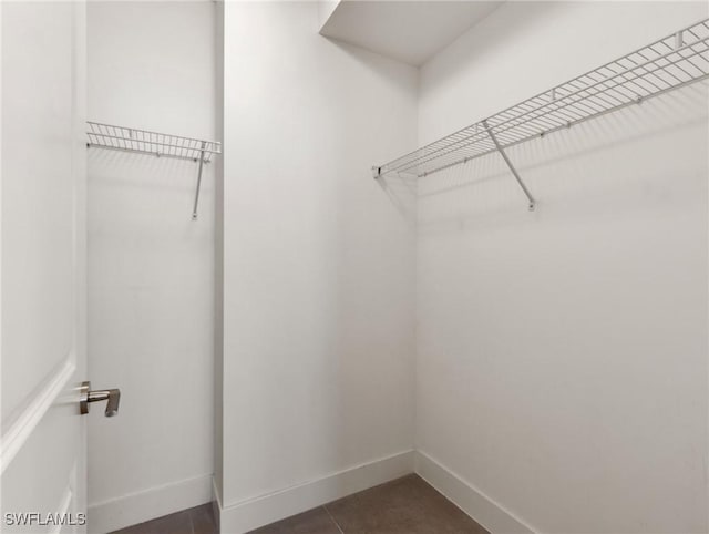 spacious closet with dark tile patterned flooring