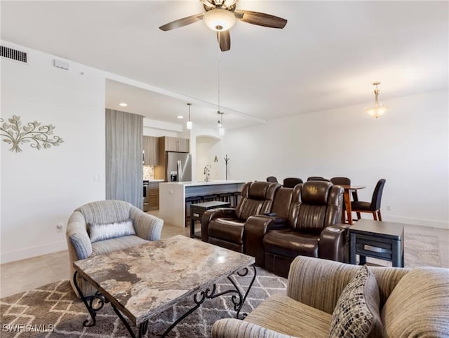 living room with ceiling fan and sink