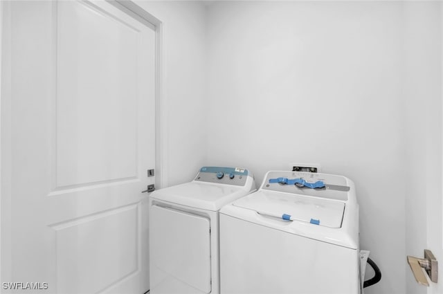 clothes washing area featuring separate washer and dryer